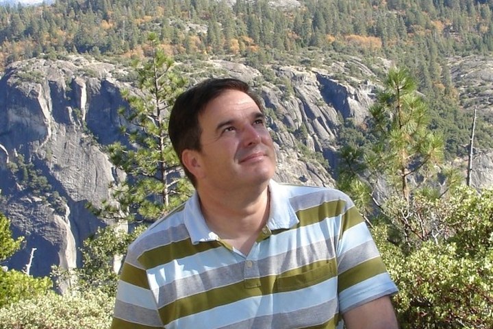 Michael McAnally outdoors in the Sierra Nevada, granite cliffs and pines behind him